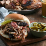 Smoked Pork Butt servedon hamburger bun with jalepenos