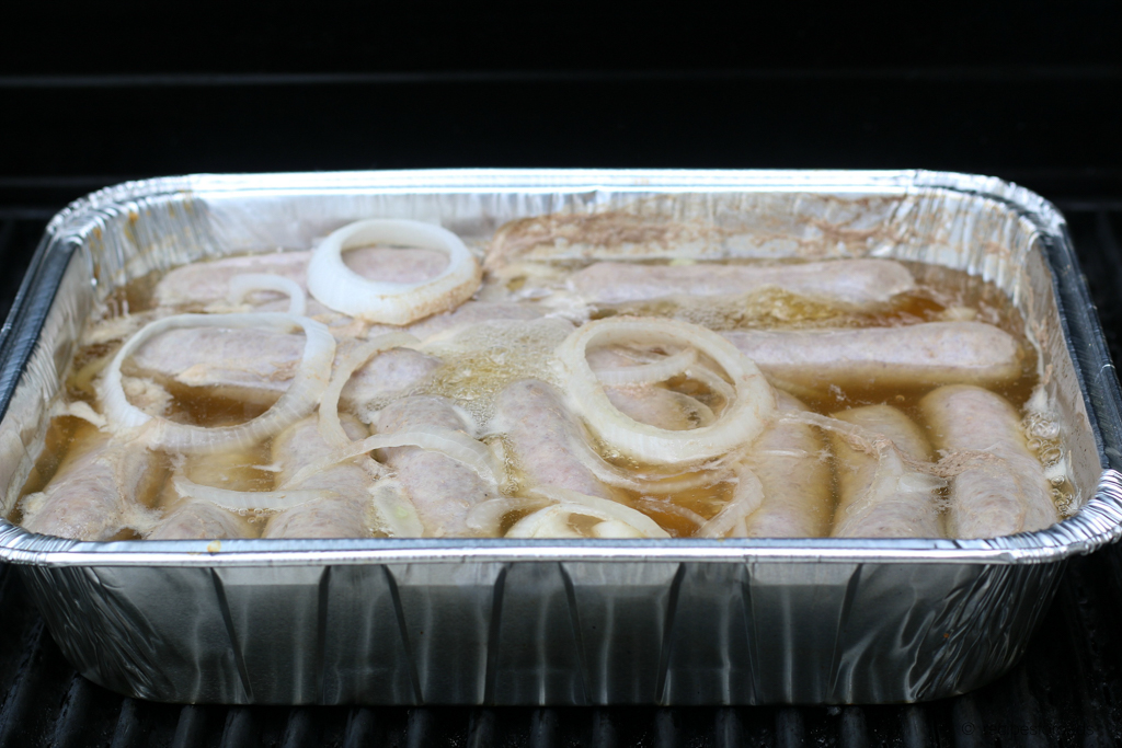 grilled brats soaking in beer and onions