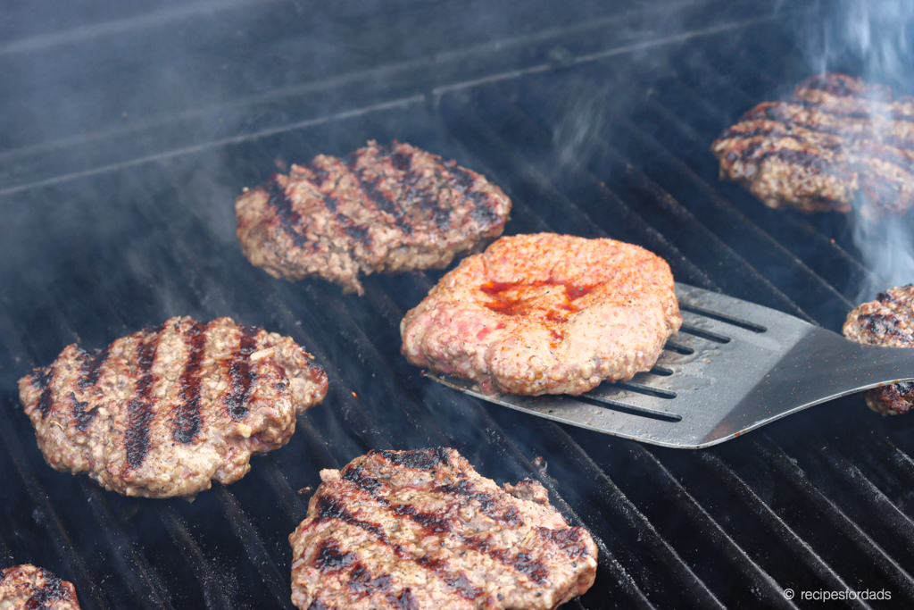 flipping hamburgers on the grill