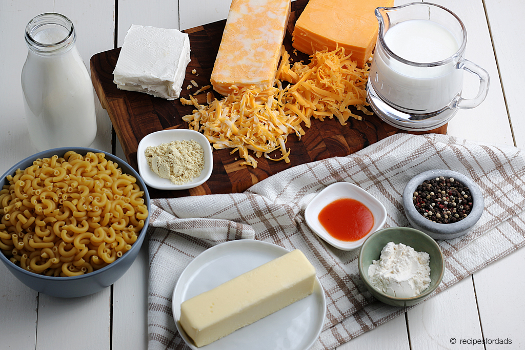 seasonings and ingredients used with homemade macaroni and cheese, served on a white board