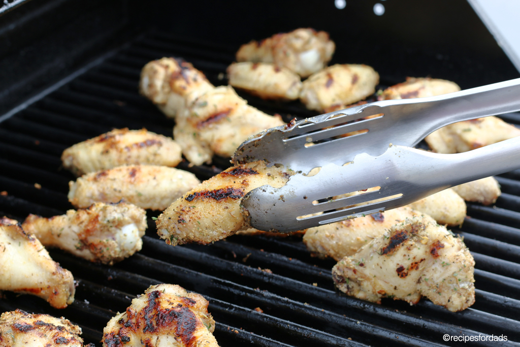 Flipping chicken wings on grill
