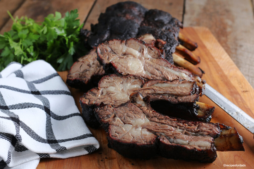 Smoked beef ribs sliced, served on cutting board