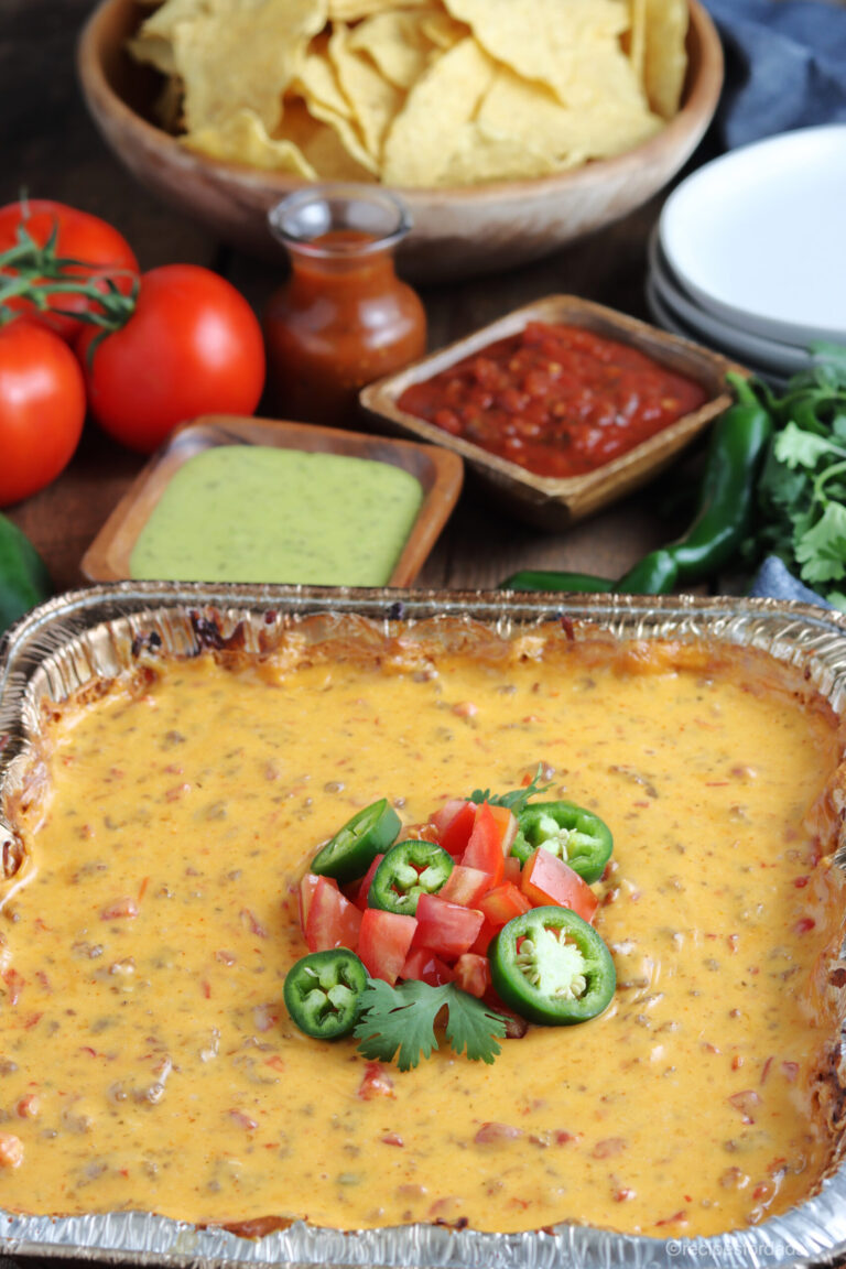 smoked queso dip topped with tomatoes and jalepenos