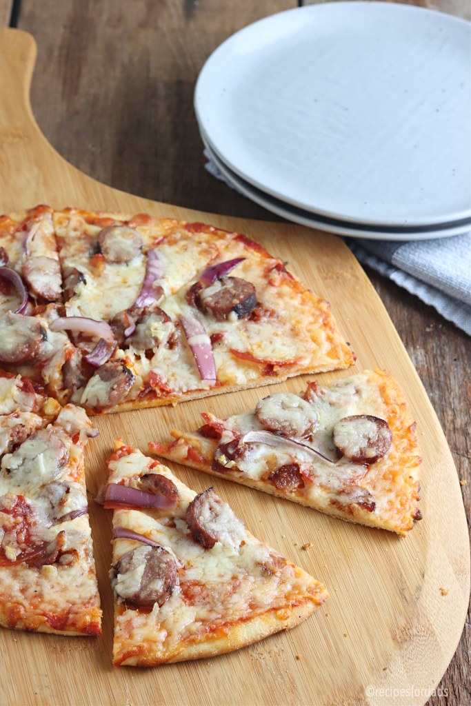 smoked pizza with sausage and bacon served on a pizza pan