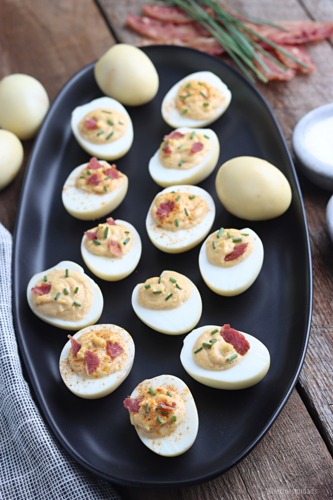 deviled eggs served on black dish