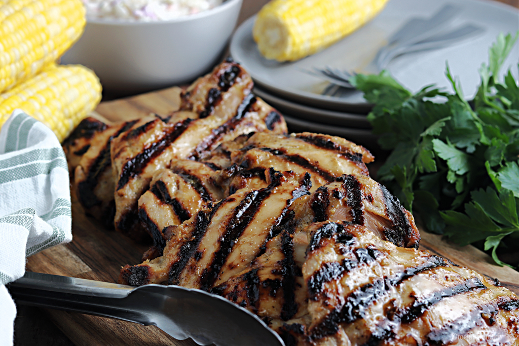 Grilled boneless chicken thighs served with yellow corn and coleslaw