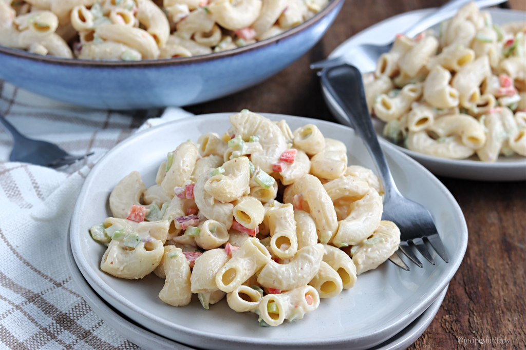 serving macaroni salad on white dish