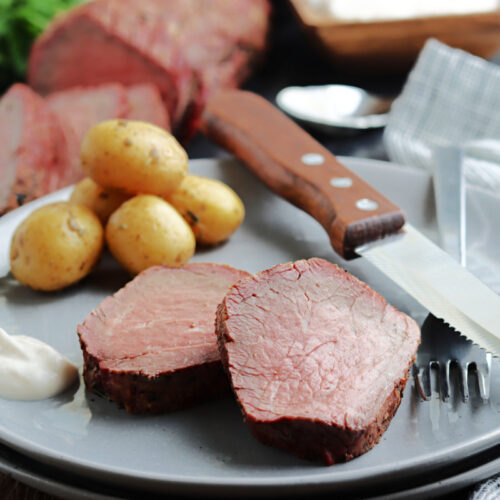 smoked beef tenderloin sliced and served on a gray plate