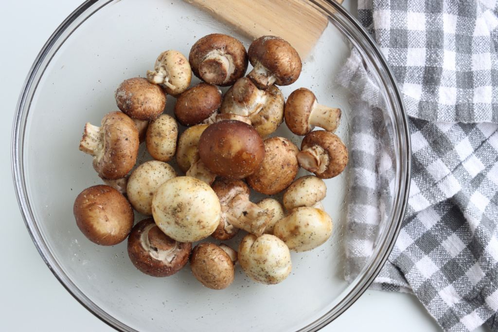mushrooms in glass bowl with oil and seasoning