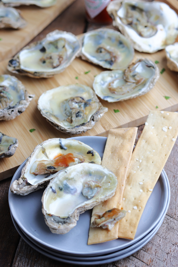 smoked oysters on wood boards with hot sauce