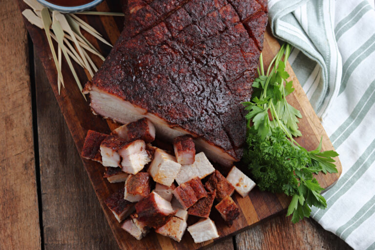 Smoked Pork Belly cut on cutting board with sauce