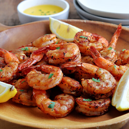 smoked shrimp in wood bowl with parsley and lemon wedges