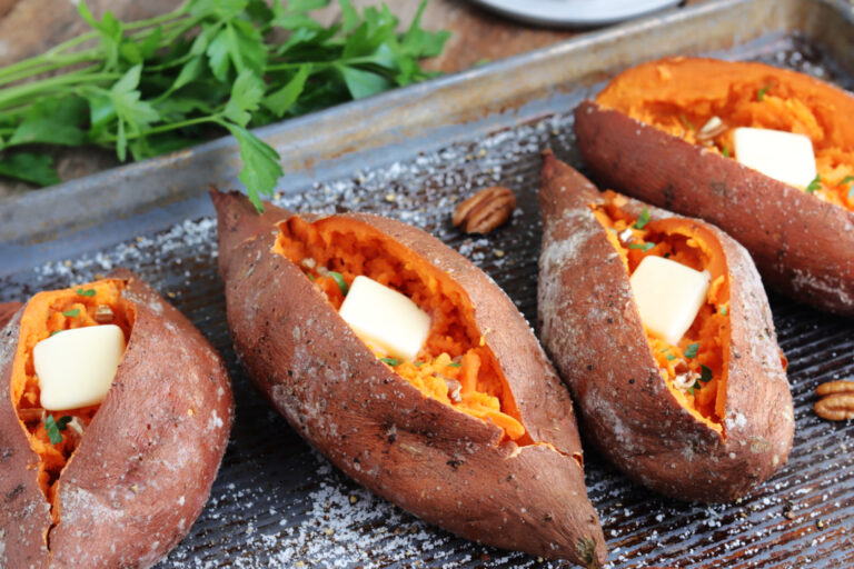 smoked sweet potatoes with butter, parsley and pecans on a pan